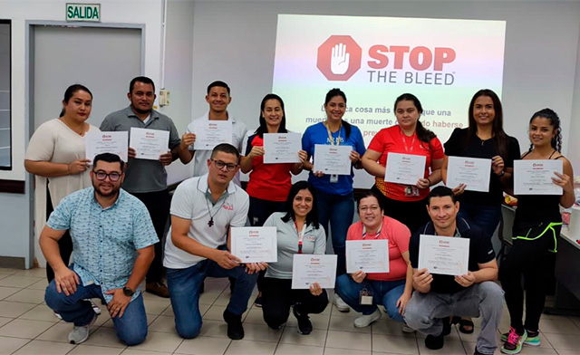 Se muestran varias personas entre hombres y mujeres, posando sosteniendo un titulo en sus manos.